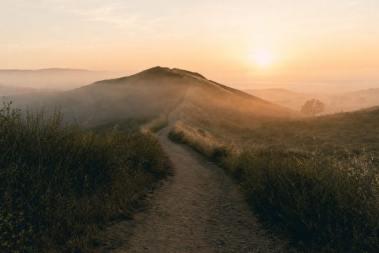 Chemin à l'aube disparaissant à l'horizon, image de l'avenir inconnu et de la confiance en le décret d'Allah